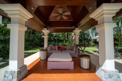 a covered patio with a couch and a table at Saitaan,4BR seaside garden pool villa, Laguna area in Bang Tao Beach