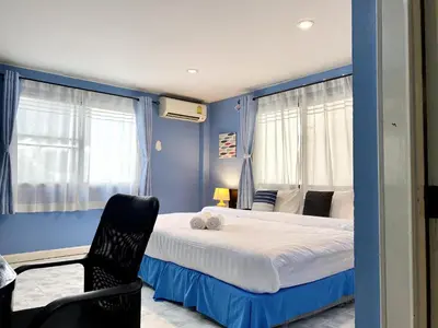 a blue bedroom with a bed and a chair at Minotel Patong in Patong Beach