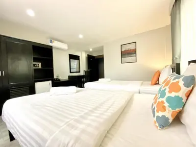 a hotel room with two beds and a bathroom at Minotel Patong in Patong Beach