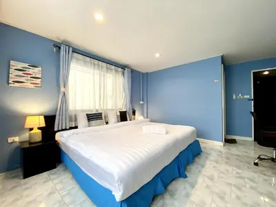 a bedroom with a large bed with blue walls at Minotel Patong in Patong Beach