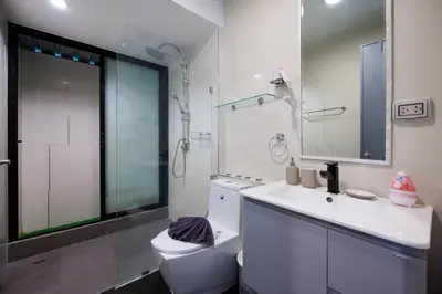 a bathroom with a toilet and a sink and a mirror at Modern & fun pool villa at Kamala regent in Kamala Beach