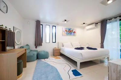 a bedroom with a bed and a tv and a couch at Modern & fun pool villa at Kamala regent in Kamala Beach