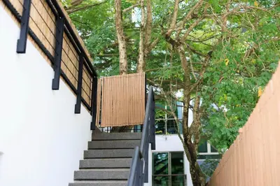 a staircase leading up to a building with trees at Modern & fun pool villa at Kamala regent in Kamala Beach