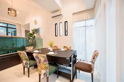 a dining room with a table and chairs and a piano at Modern & fun pool villa at Kamala regent in Kamala Beach