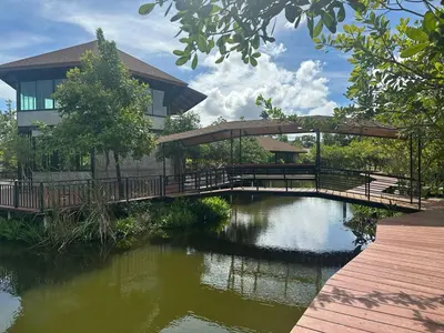 a bridge over a pond in front of a building at The Beatles Lagoon in Ban Na Bon
