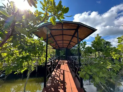 a covered walkway next to a body of water at The Beatles Lagoon in Ban Na Bon