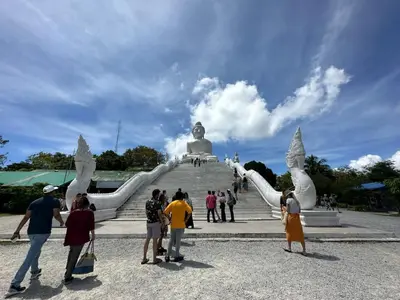a group of people standing in front of a statue at The Beatles Lagoon in Ban Na Bon