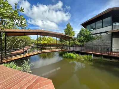 a house with a pond in front of a building at The Beatles Lagoon in Ban Na Bon