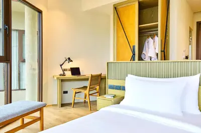 a bedroom with a bed and a desk with a laptop at Beyond Skywalk Nangshi in Ban Met Nang Chi
