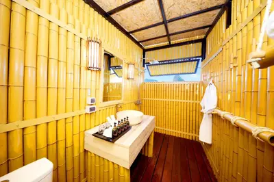 a bathroom with yellow bamboo walls and a sink at Beyond Skywalk Nangshi in Ban Met Nang Chi