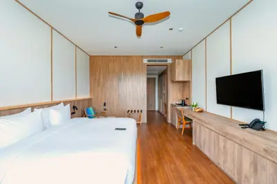 a bedroom with a bed and a flat screen tv at Beyond Skywalk Nangshi in Ban Met Nang Chi