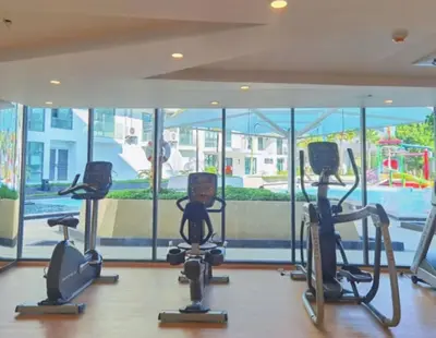 a gym with cardio equipment in front of a large window at Water park Rawai Beach 200m Nai Han king bedroom in Rawai Beach