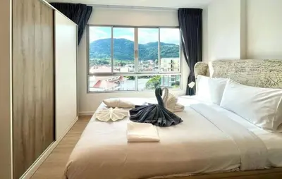 a bedroom with a large bed with a large window at Dcondo Kathu - Top Floor 1 Bdr Condo with shared Pool in Kathu