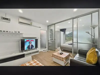 a living room with a couch and a tv in it at Dcondo Kathu - Top Floor 1 Bdr Condo with shared Pool in Kathu