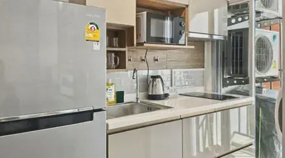 a kitchen with a stainless steel refrigerator and a sink at Dcondo Kathu - Top Floor 1 Bdr Condo with shared Pool in Kathu