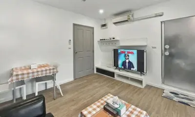 a living room with a flat screen tv and a couch at Dcondo Kathu - Top Floor 1 Bdr Condo with shared Pool in Kathu