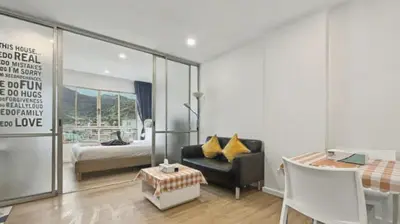 a living room with a bed and a chair and a table at Dcondo Kathu - Top Floor 1 Bdr Condo with shared Pool in Kathu