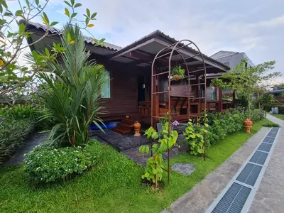 a house with a garden in front of it at Baan Ati Resort & Spa in Ban Na Tai