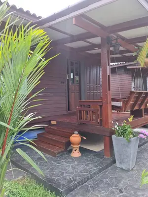 a wooden house with a bench and a porch at Baan Ati Resort & Spa in Ban Na Tai
