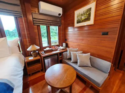a bedroom with a bed and a table and a bench at Baan Ati Resort & Spa in Ban Na Tai