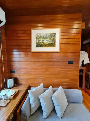 a living room with a couch and a wooden wall at Baan Ati Resort & Spa in Ban Na Tai