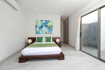 a bedroom with a bed and a large window at 4bdr Pool Villa Suksan Rawai by CapitalPro SUK-20-154 in Phuket Town
