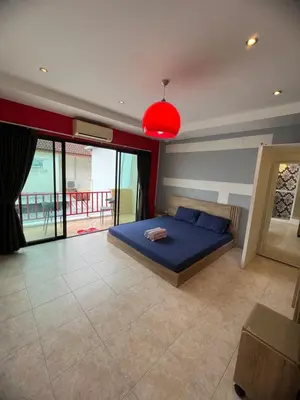 a bedroom with a blue bed and a red lamp at Petunya Room 2 in Ban Huai Luk (1)