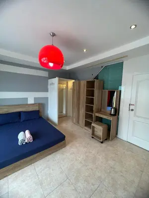 a bedroom with a blue bed and a red lamp at Petunya Room 2 in Ban Huai Luk (1)