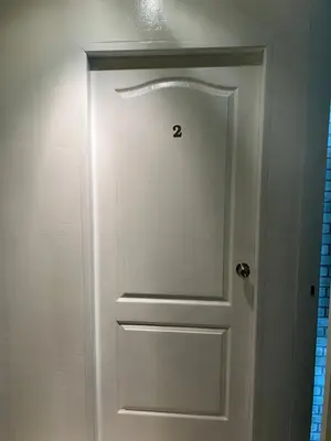 a door with a number on it in a bathroom at Petunya Room 2 in Ban Huai Luk (1)