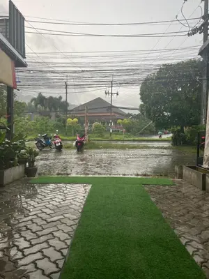 a flooded street with two motorcycles parked in it at Petunya Room 1 in Ban Huai Luk (1)
