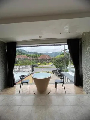 a large room with a large tub and two chairs at Petunya Room 1 in Ban Huai Luk (1)
