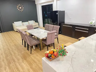 a dining room with a table and chairs with a bowl of fruit at Spacious Private Villa Modern Style near beach in Thai Muang