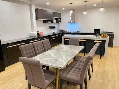 a kitchen with a table and chairs and a counter at Spacious Private Villa Modern Style near beach in Thai Muang