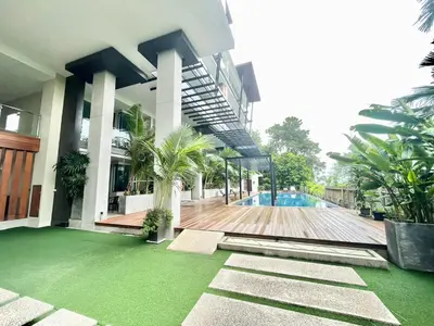 a building with a swimming pool in front of a house at 1 Bedroom Rawai Walk to beach in Rawai Beach