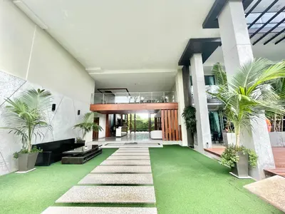 a house with a green lawn in front of it at 1 Bedroom Rawai Walk to beach in Rawai Beach