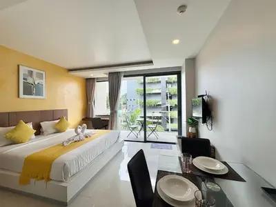 a bedroom with a large bed and a dining table at 1 Bedroom Rawai Walk to beach in Rawai Beach