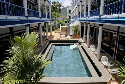 a swimming pool in the middle of a building at The Club Inn - Kamala Beach in Kamala Beach