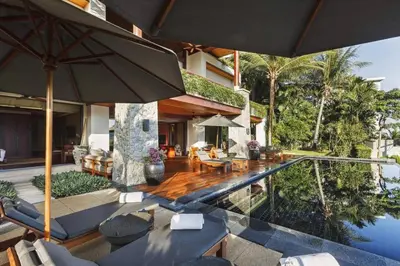 a house with a swimming pool and an umbrella at Andarada Seaview in Kamala Beach