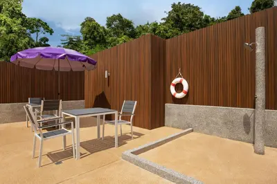 a patio with a table and chairs and an umbrella at Aspira Resort Klong Muang Krabi in Klong Muang Beach