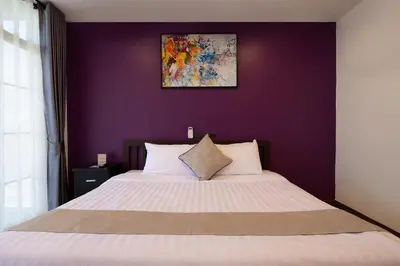 a bedroom with a large bed with a purple wall at Aspira Resort Klong Muang Krabi in Klong Muang Beach