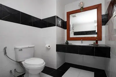 a bathroom with a toilet and a sink and a mirror at Aspira Resort Klong Muang Krabi in Klong Muang Beach