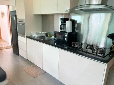 a kitchen with white cabinets and a black counter top at Intimate Oasis, 2 bedrooms Pool in Kata Beach