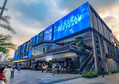 a large building with people standing outside of it at Quiet Patong Apartment near Night Life & Good Food in Patong Beach