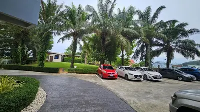 three cars parked in a parking lot with palm trees at Апартаменты с видом на море на Карон Бич А 409 in Karon Beach