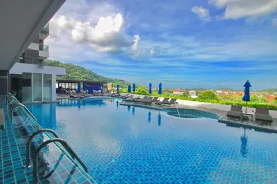 a swimming pool with a view of a resort at The Yama Hotel Phuket in Kata Beach