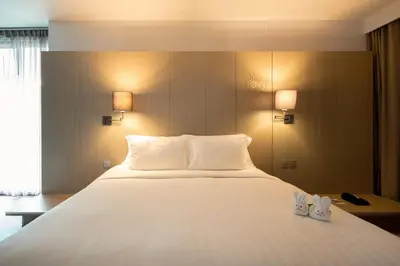 a large white bed in a hotel room at The Yama Hotel Phuket in Kata Beach