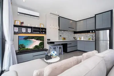 a living room with a white couch and a television at Tropics Kamala Hill View Suite CTG P610 near Beach and Fantasea in Kamala Beach