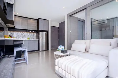 a living room with a white couch and a kitchen at Tropics Kamala Hill View Suite CTG P610 near Beach and Fantasea in Kamala Beach