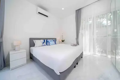 a white bedroom with a large bed and a window at Brand New 3 Bedroom Pool Villa in Ban Saiyuan (1)