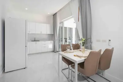 a white dining room with a table and chairs at Brand New 3 Bedroom Pool Villa in Ban Saiyuan (1)